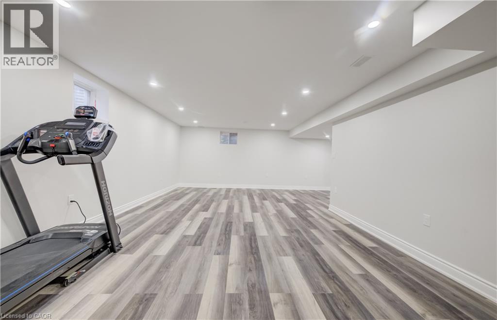 Spacious finished room featuring wood-finish flooring, recessed lighting, and white baseboards - 52 Pointer Street, Cambridge, ON - Indoor Photo Showing Gym Room