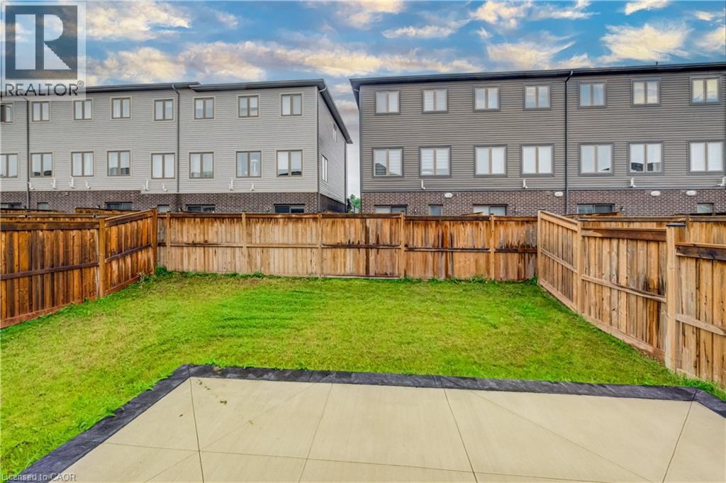 Private backyard featuring a concrete patio, perimeter wood fencing, and a manicured lawn - 52 Pointer Street, Cambridge, ON - Outdoor