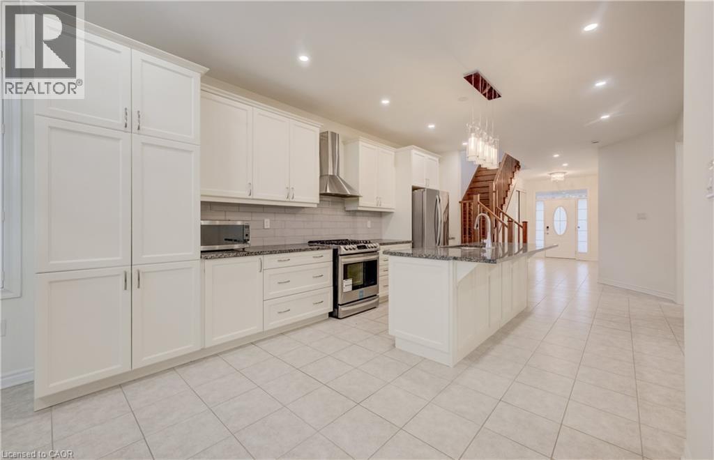 Kitchen featuring white shaker-style cabinetry, stainless steel appliances, granite countertops, and a subway tile backsplash - 52 Pointer Street, Cambridge, ON - Indoor Photo Showing Kitchen With Upgraded Kitchen