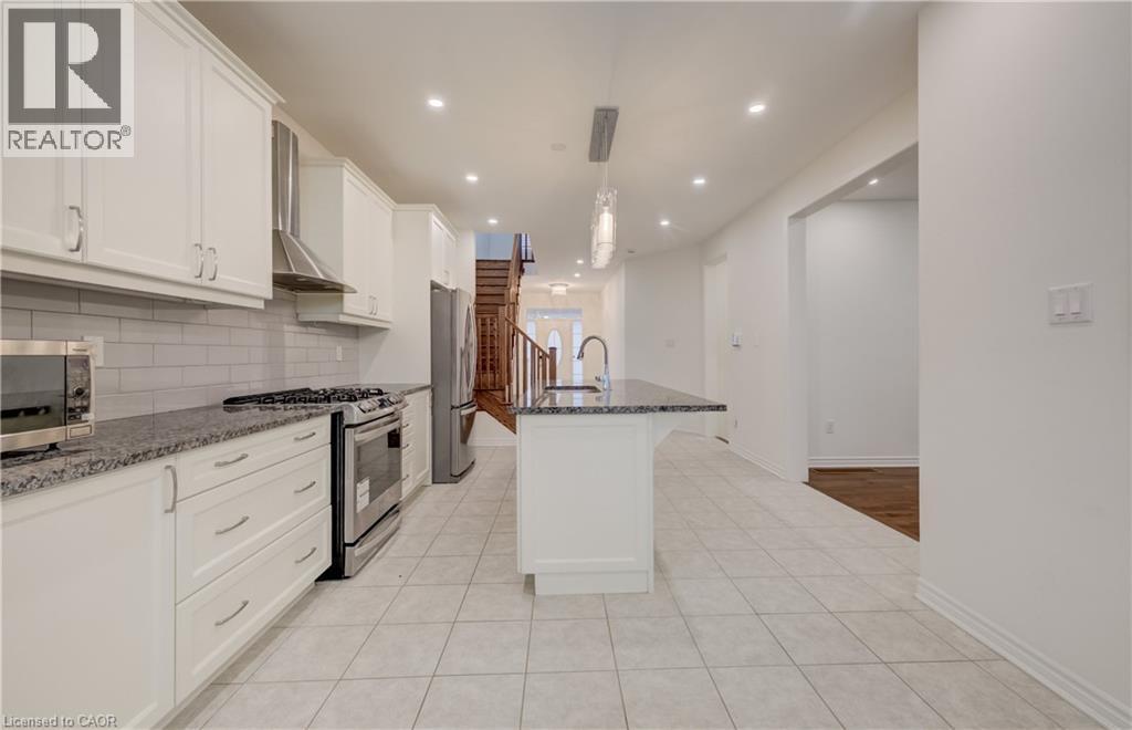 Modern kitchen featuring white shaker cabinetry, stainless steel appliances, granite countertops, and a subway tile backsplash - 52 Pointer Street, Cambridge, ON - Indoor Photo Showing Kitchen With Upgraded Kitchen