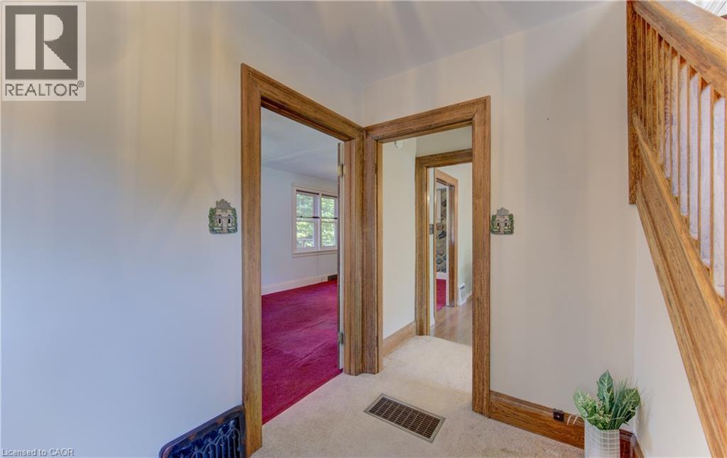 Carpeted hallway with wood trim and a natural wood staircase - 224 Weber Street E, Kitchener, ON - Indoor Photo Showing Other Room