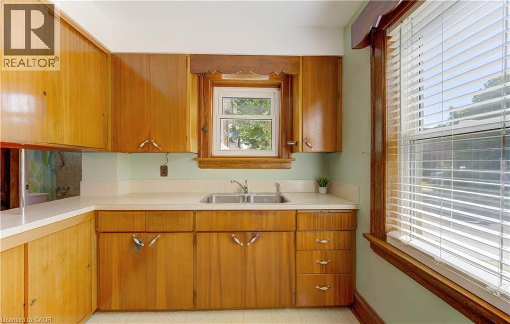 Kitchen featuring wood cabinetry, dual basin sink, and wood-trimmed windows - 224 Weber Street E, Kitchener, ON - Indoor Photo Showing Kitchen With Double Sink