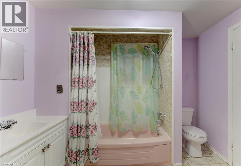 Bathroom featuring a built-in bathtub with shower, toilet, and a vanity with an integrated sink and base cabinetry - 224 Weber Street E, Kitchener, ON - Indoor Photo Showing Bathroom