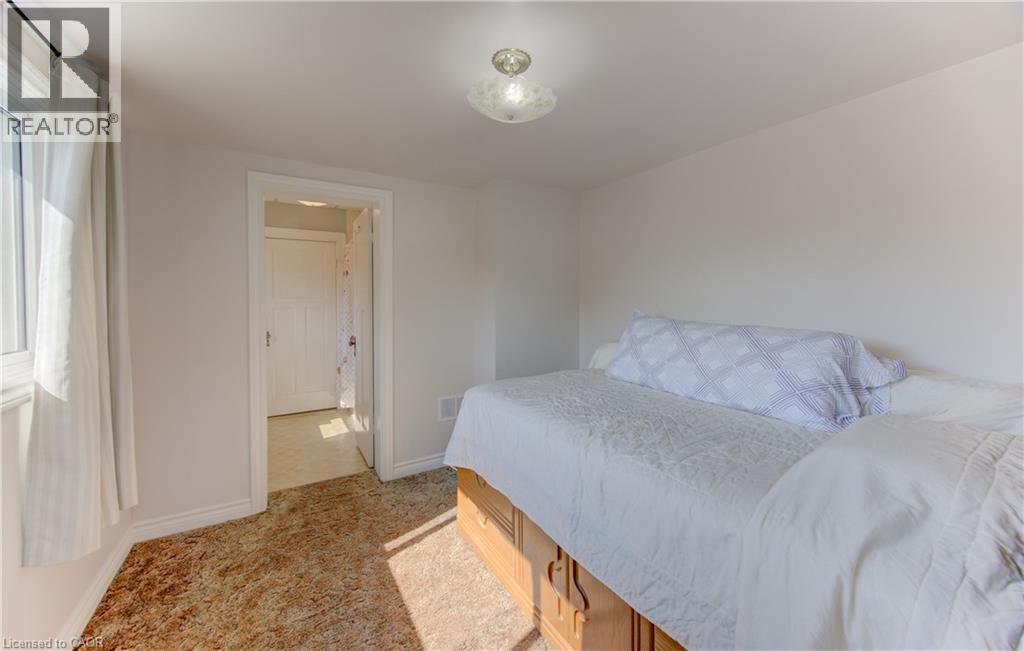 Carpeted bedroom with a window, baseboard trim, and a ceiling light fixture - 224 Weber Street E, Kitchener, ON - Indoor Photo Showing Bedroom
