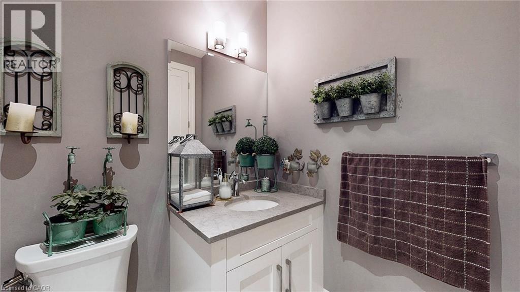 Bathroom featuring a single vanity with a stone-finish countertop, undermount sink, and a framed mirror - 537 Millstream Drive, Waterloo, ON - Indoor Photo Showing Bathroom