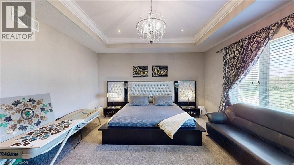 Spacious bedroom with a tray ceiling, recessed lighting, and a crystal chandelier - 537 Millstream Drive, Waterloo, ON - Indoor Photo Showing Bedroom