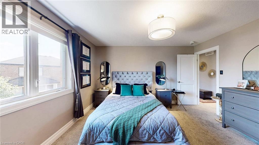 Carpeted room featuring a large window, a ceiling-mounted drum light fixture, a solid interior door, and neutral wall tones - 537 Millstream Drive, Waterloo, ON - Indoor Photo Showing Bedroom