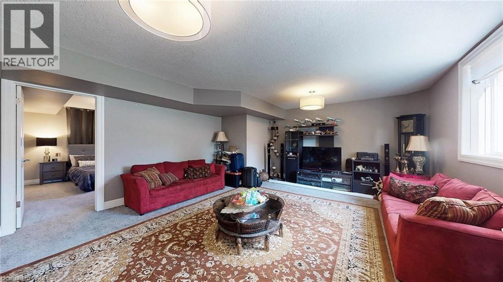 Spacious living area featuring carpet flooring, neutral wall tones, and a built-in media console - 537 Millstream Drive, Waterloo, ON - Indoor Photo Showing Living Room