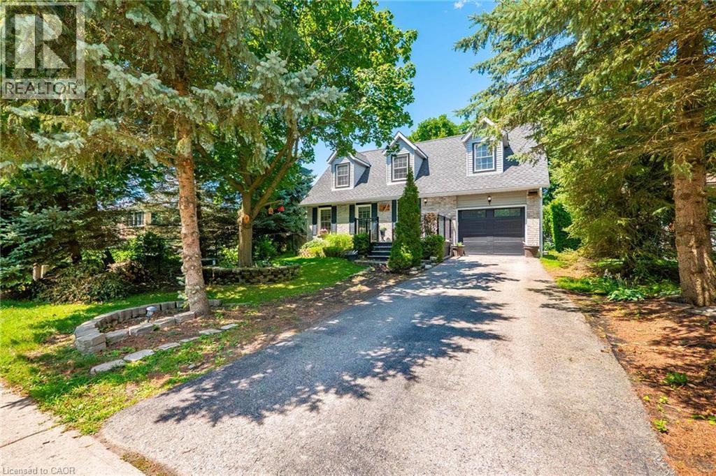Stone and siding exterior featuring a multi-dormer roofline, an attached garage, and a paved driveway - 34 Peachtree Crescent, Cambridge, ON - Outdoor With Facade