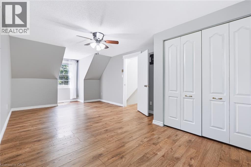 Spacious room featuring wood-finish flooring, light grey walls, and a multi-pane window - 34 Peachtree Crescent, Cambridge, ON - Indoor Photo Showing Other Room