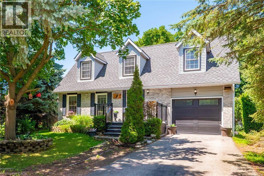 Exterior featuring a combination of light-colored stone and horizontal siding, a dark gray shingle roof, and three prominent dormer windows - 34 Peachtree Crescent, Cambridge, ON - Outdoor With Facade