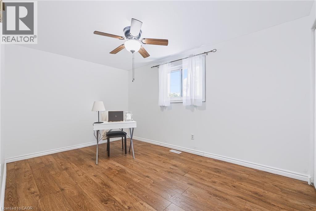 Room featuring wood-finish flooring, white baseboards, and a ceiling fan with integrated lighting - 34 Peachtree Crescent, Cambridge, ON - Indoor Photo Showing Other Room