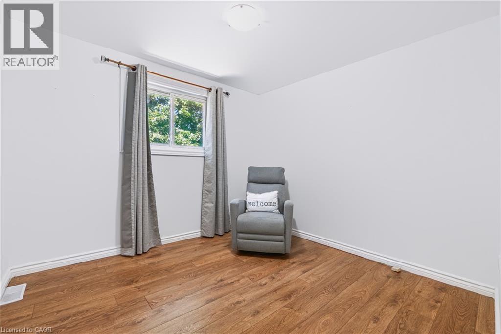 Bright room featuring wood-finish flooring, white baseboards, a single window, and a flush-mount ceiling light - 34 Peachtree Crescent, Cambridge, ON - Indoor