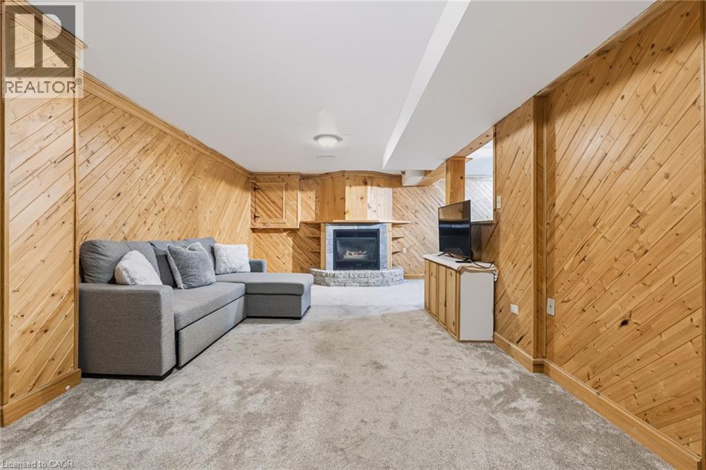 Spacious room featuring diagonal wood paneling and a carpeted floor - 34 Peachtree Crescent, Cambridge, ON - Indoor With Fireplace