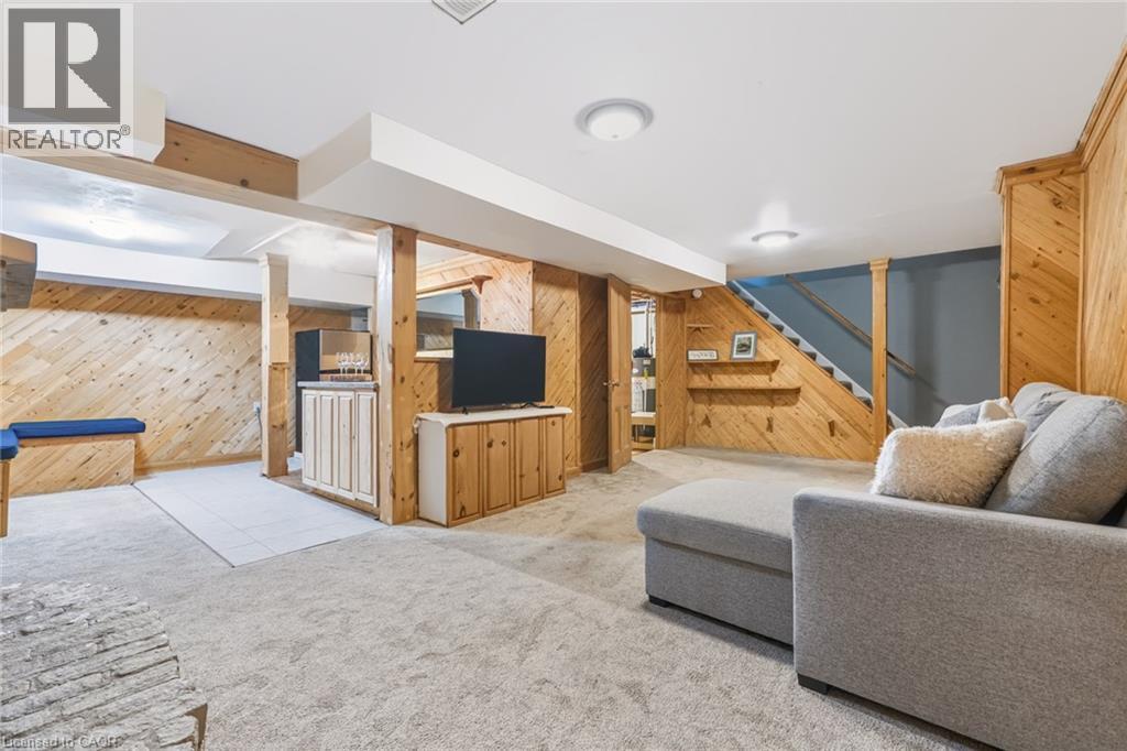 Finished basement featuring light wood paneling, built-in cabinetry, and neutral carpeting - 34 Peachtree Crescent, Cambridge, ON - Indoor