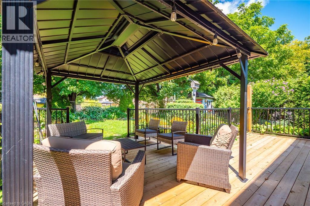 Spacious wood-finish deck featuring a black metal gazebo with integrated lighting - 34 Peachtree Crescent, Cambridge, ON - Outdoor With Deck Patio Veranda With Exterior