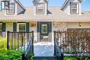 Front exterior featuring light-toned brick, dormer windows, and a black paneled entry door with decorative glass - 34 Peachtree Crescent, Cambridge, ON  - Outdoor With Deck Patio Veranda 