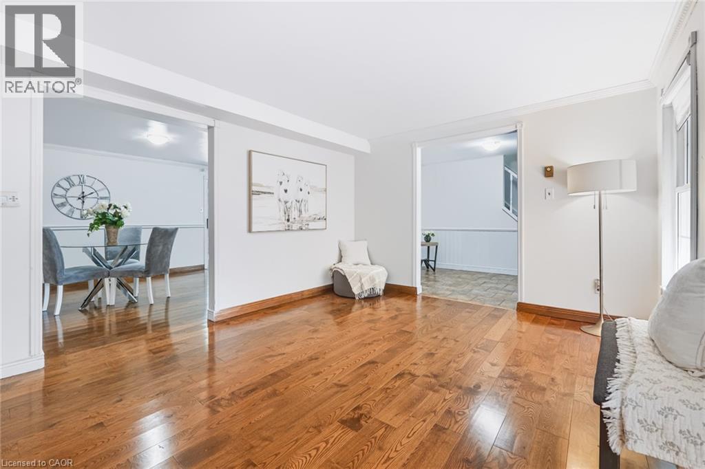 Warm wood-finish flooring extends through this open living area - 34 Peachtree Crescent, Cambridge, ON - Indoor Photo Showing Other Room