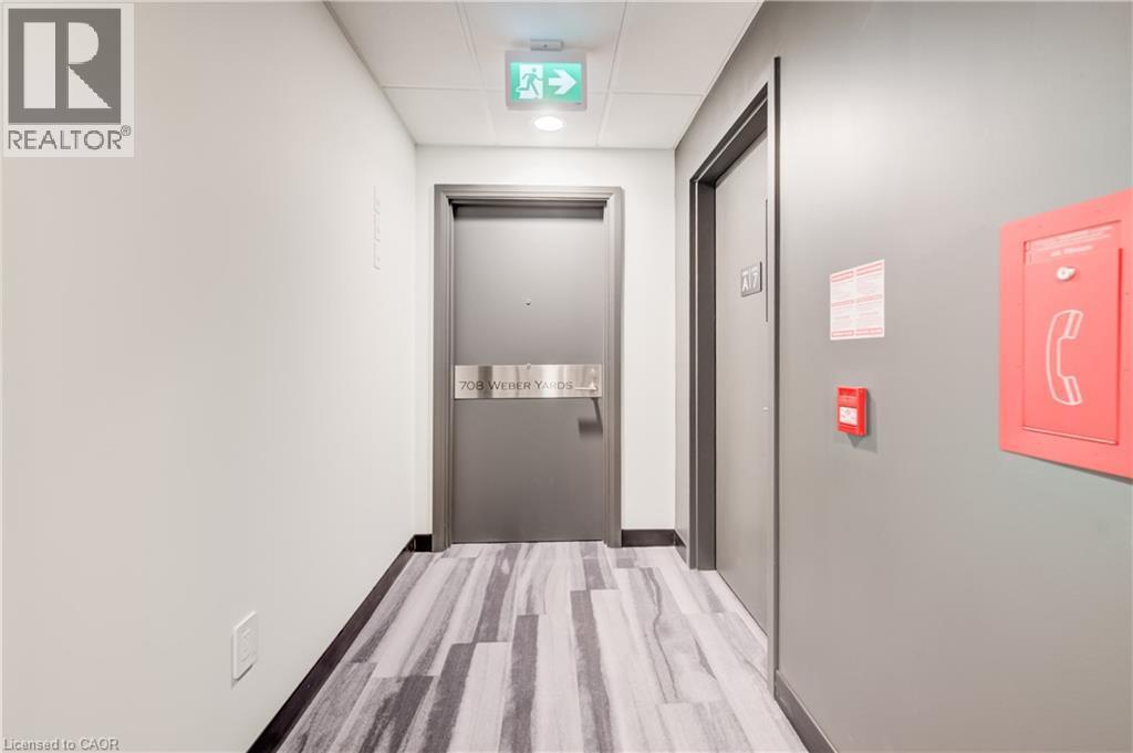 Hallway featuring a light-toned wall finish, wood-finish flooring, and recessed ceiling lighting - 1333 Weber Street E Unit# 708, Kitchener, ON - Indoor
