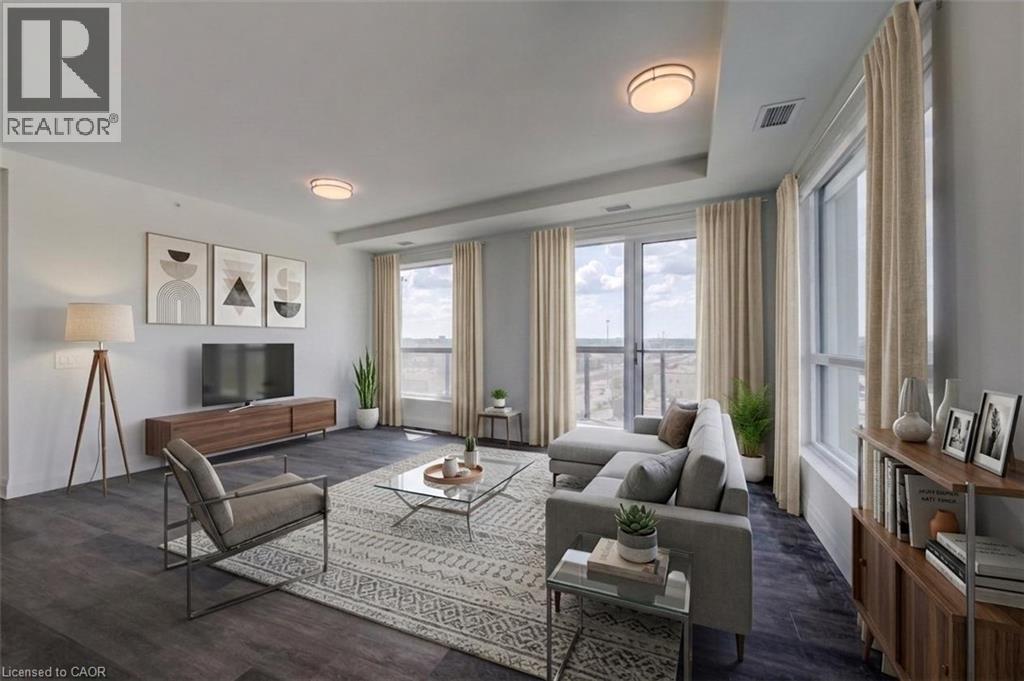 Spacious living area featuring dark wood-finish flooring, a wall of windows, and a glass-paneled door opening to an outdoor area - 1333 Weber Street E Unit# 708, Kitchener, ON - Indoor Photo Showing Living Room