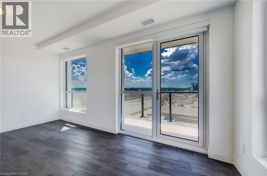 Spacious room featuring wood-finish flooring, white walls, and a recessed ceiling - 1333 Weber Street E Unit# 708, Kitchener, ON - Indoor Photo Showing Other Room