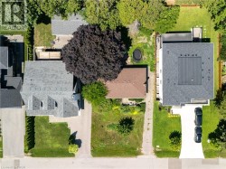 Aerial perspective showcasing three distinct properties, each with unique rooflines and yard configurations - 