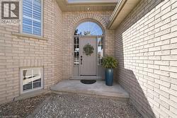 Light-colored brick exterior featuring an arched entryway with a transom window - 