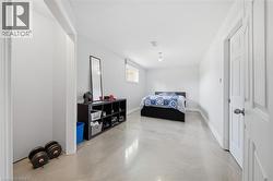 Spacious room featuring light gray walls, a window, and a white interior door - 