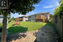 Expansive backyard featuring a manicured lawn, a two-story wood deck, and solar panels - 