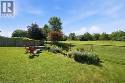 Expansive green lawn with a mature tree backdrop - 