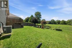 Expansive green lawn with a wooden deck featuring horizontal railings - 