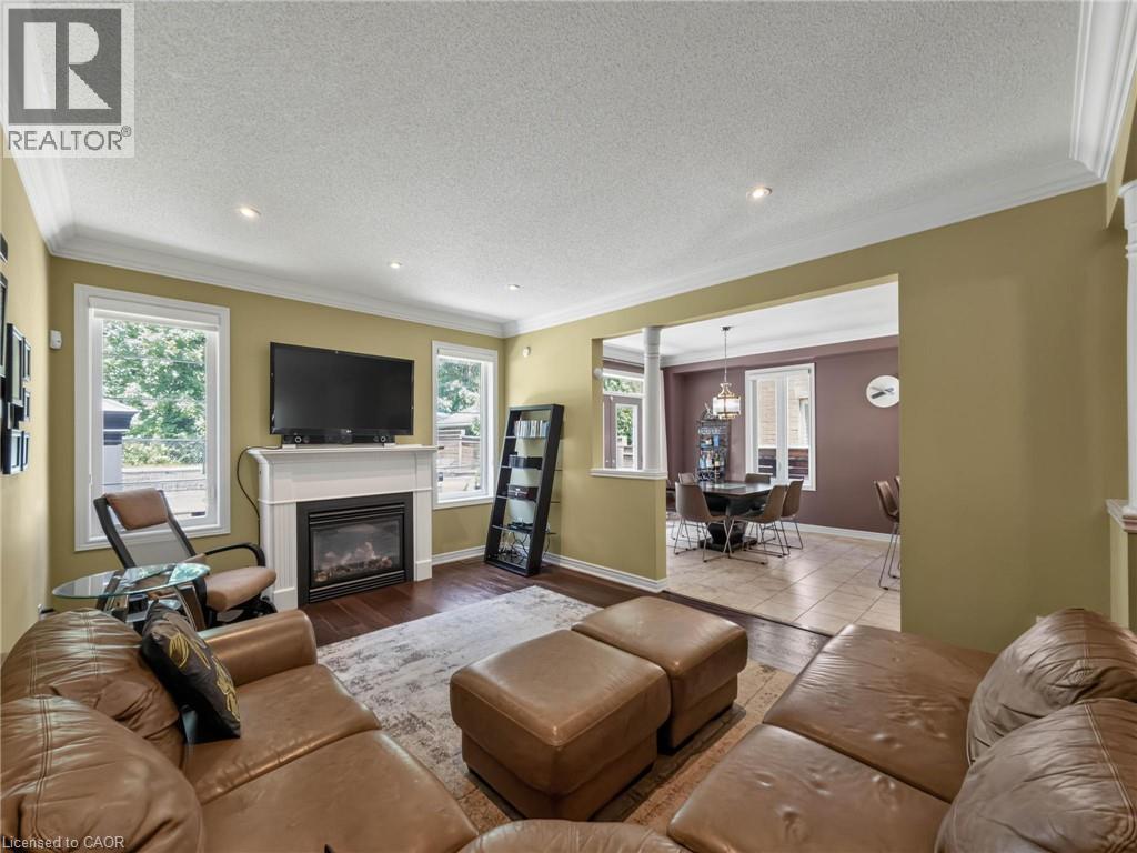 Living area featuring a fireplace with a white mantel, recessed lighting, and crown molding - 80 Sutherland Crescent, Ancaster, ON - Indoor Photo Showing Living Room With Fireplace