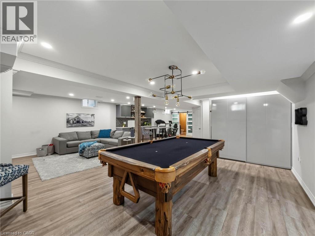 Recreation room featuring wood-finish flooring, recessed lighting, and a contemporary chandelier - 80 Sutherland Crescent, Ancaster, ON - Indoor Photo Showing Other Room