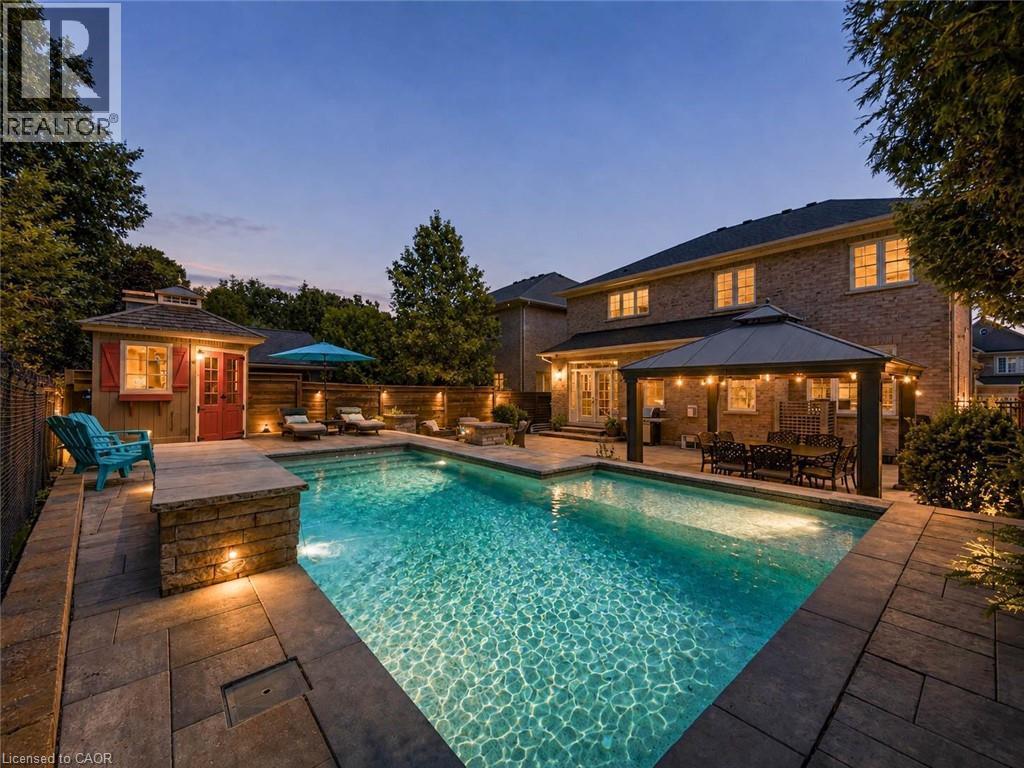 Rectangular swimming pool with integrated lighting and surrounding stone paver patio - 80 Sutherland Crescent, Ancaster, ON - Outdoor With In Ground Pool With Deck Patio Veranda With Backyard