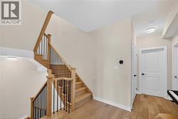 Hardwood staircase with black metal balusters and natural wood handrails - 