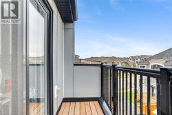 Private balcony featuring wood-finish flooring and black metal railings - 