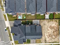 Aerial view showcasing a modern residential property with a striking dark-toned roof featuring geometric architectural lines - 