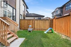 Private backyard featuring a well-maintained lawn and sturdy wood fencing - 
