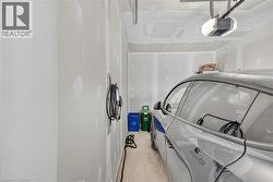 Spacious garage featuring a concrete floor, automatic garage door opener, and a dedicated electric vehicle charging station - 