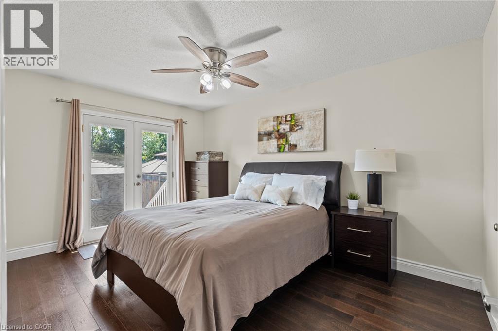 Spacious room featuring wood-finish flooring, a ceiling fan with integrated lighting, and a white popcorn ceiling - 167 Berkindale Drive, Hamilton, ON - Indoor Photo Showing Bedroom