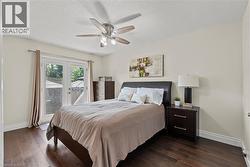 Spacious room featuring wood-finish flooring, a ceiling fan with integrated lighting, and a white popcorn ceiling -