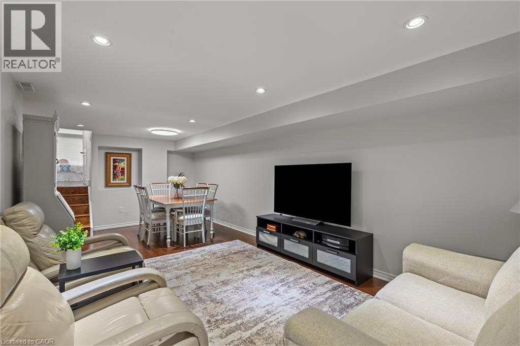 Finished lower level featuring recessed lighting, wood-finish flooring, and a dedicated dining area with a built-in niche - 167 Berkindale Drive, Hamilton, ON - Indoor Photo Showing Living Room