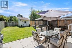 Expansive concrete patio with a hot tub gazebo and a detached storage shed -