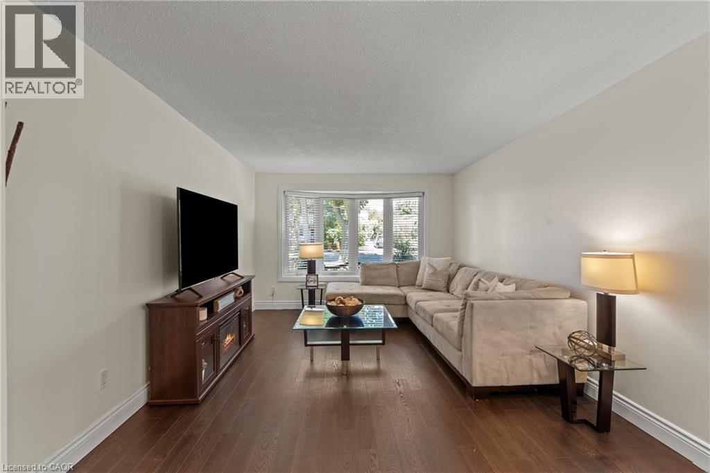 Living area featuring wood-finish flooring, light-toned walls, and a bay window - 167 Berkindale Drive, Hamilton, ON - Indoor Photo Showing Living Room