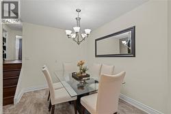 Elegant dining room featuring a glass-top table with dark wood base, paired with upholstered dining chairs in neutral tones -