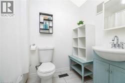 White bathroom featuring a pedestal sink with a light blue vanity, chrome fixtures, and tiled flooring - 
