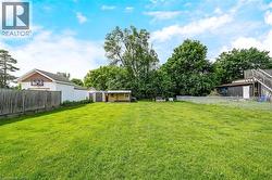 Expansive level lawn with mature tree specimens and established landscaping - 