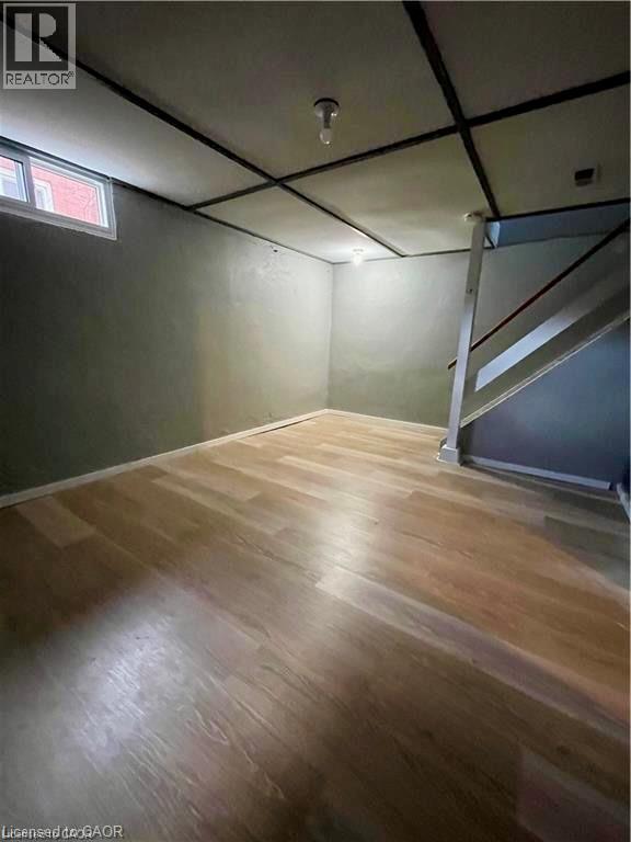 Spacious interior room featuring gleaming wood-finish flooring, exposed beam ceiling detail, and neutral wall finishes - 683 Coronation Boulevard Unit# 2, Cambridge, ON - Indoor