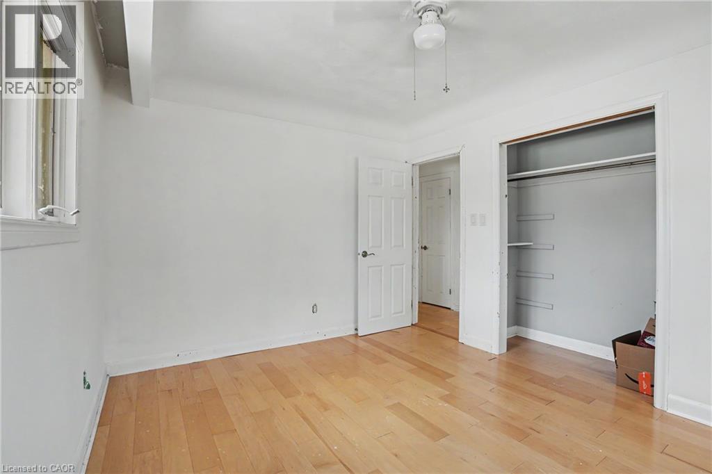 Room featuring wood-finish flooring, white walls, and a window with a white frame - 100 Hardale Crescent, Hamilton, ON - Indoor Photo Showing Other Room