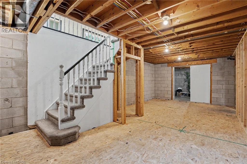 Unfinished basement featuring a carpeted staircase with white balusters and a dark handrail - 100 Hardale Crescent, Hamilton, ON - Indoor Photo Showing Basement